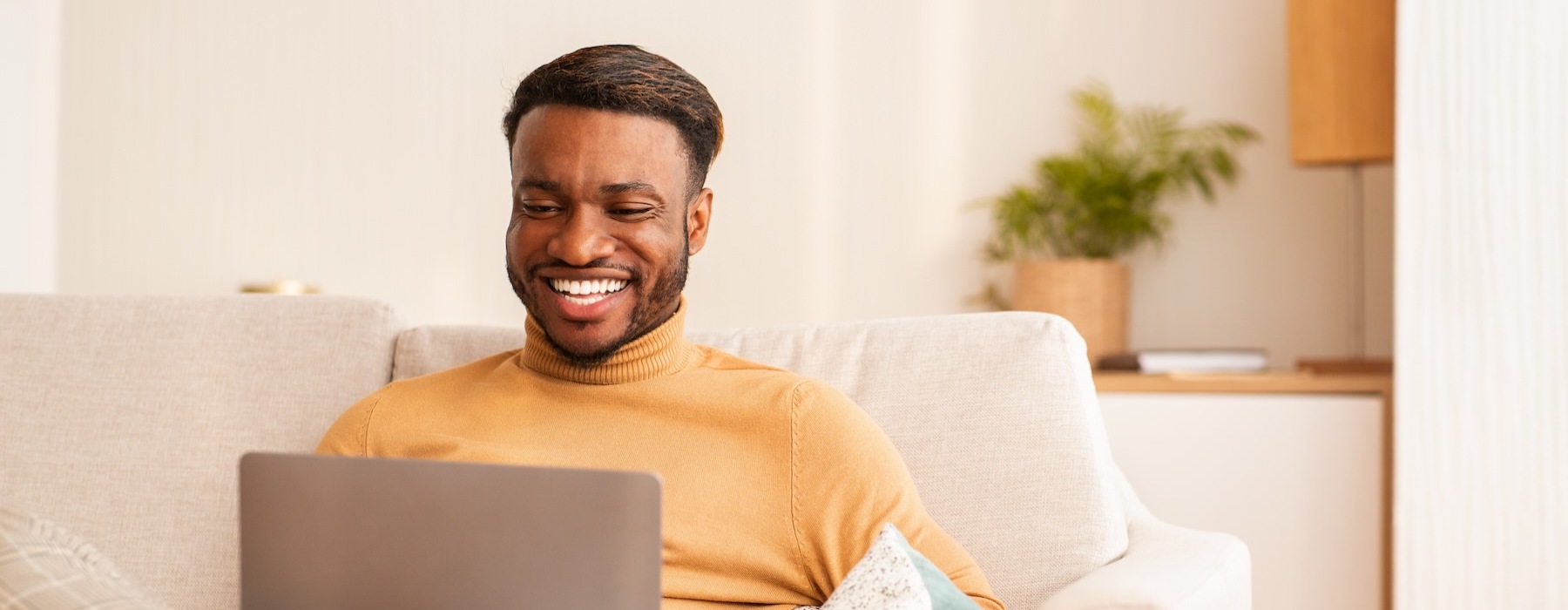 a man sitting on a couch with a laptop